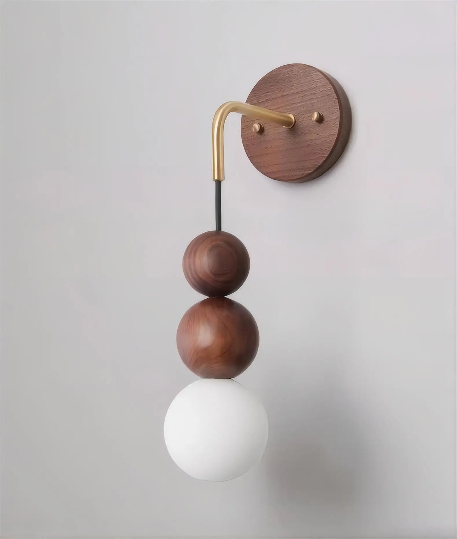 Side view of LUXELY walnut wood wall light with brass arm and matte glass globe, ideal for modern home interiors.