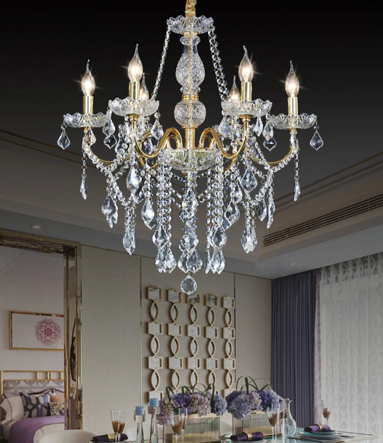 Elegant golden crystal chandelier with LED candle lights hanging in a modern dining room for ambient illumination.