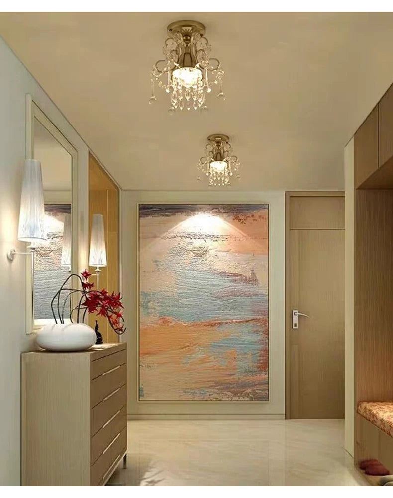 Lampadari in cristallo dorato che illuminano un ingresso moderno, conferendo eleganza agli interni di appartamenti o hotel.