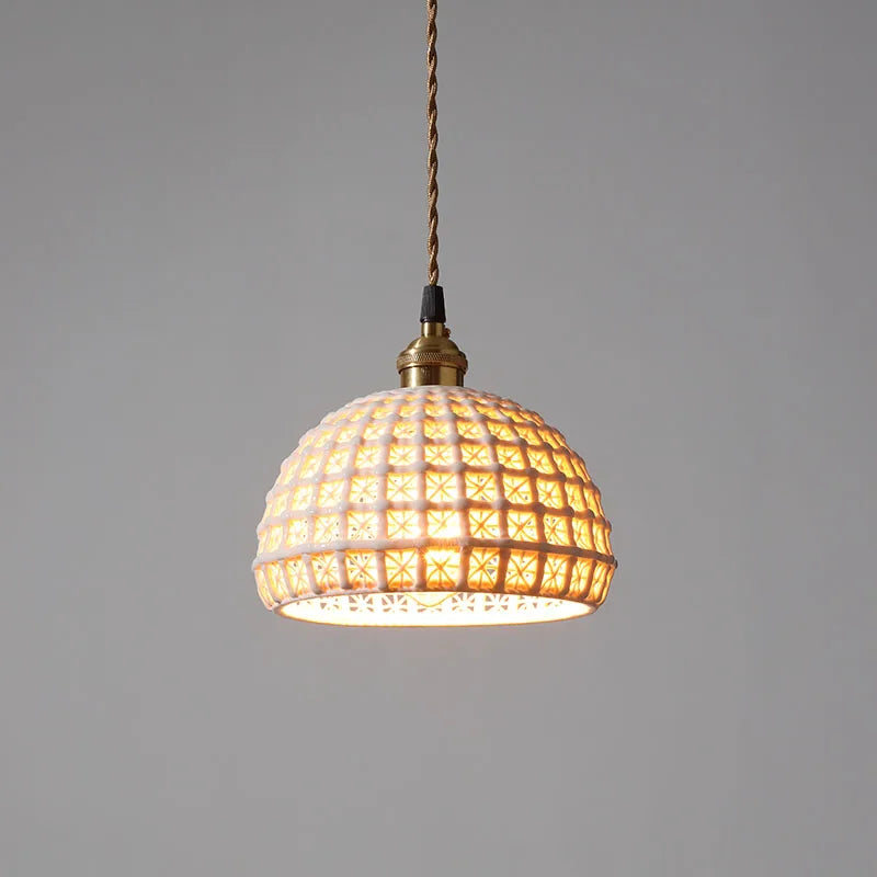 Single dome-shaped LUXELY white ceramic LED pendant light with geometric cutouts, ideal for dining or living room lighting.