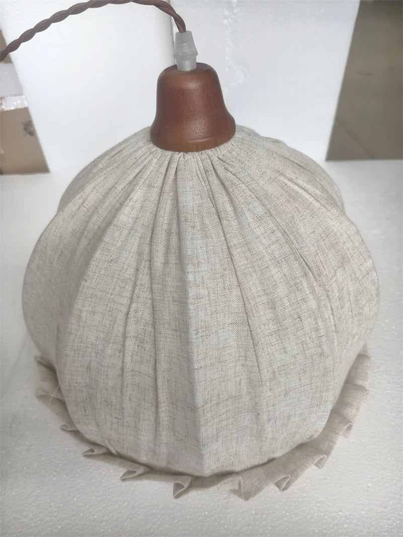 Side view of fabric pendant lamp with textured beige shade and wooden cap, designed for modern ceiling light fixtures.
