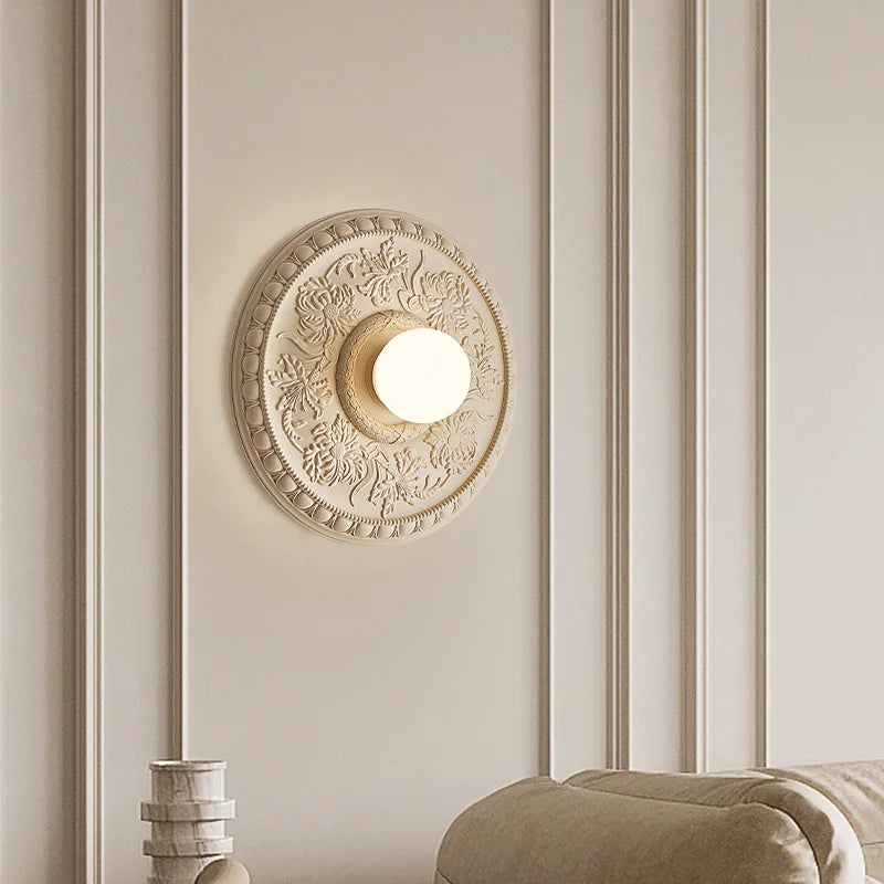 Beige retro French wall lamp with floral motif, adding a royal touch to a luxurious living room wall décor.