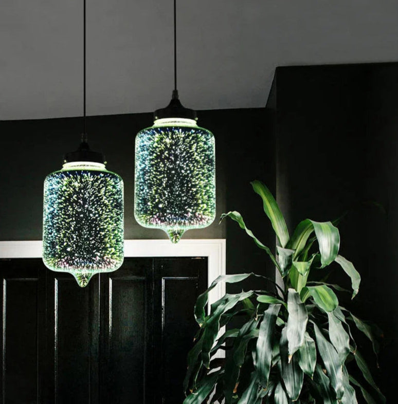 Glass 3D Fireworks Pendant Light - LED Stylish Design with cylindrical shape, hanging in a dark modern hallway beside a green plant.