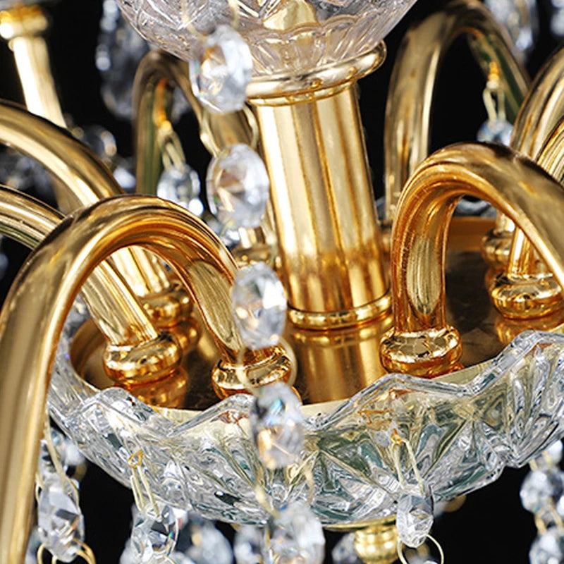 Close-up of golden crystal chandelier arm with gold finish and faceted crystal bowl for refined lighting design.