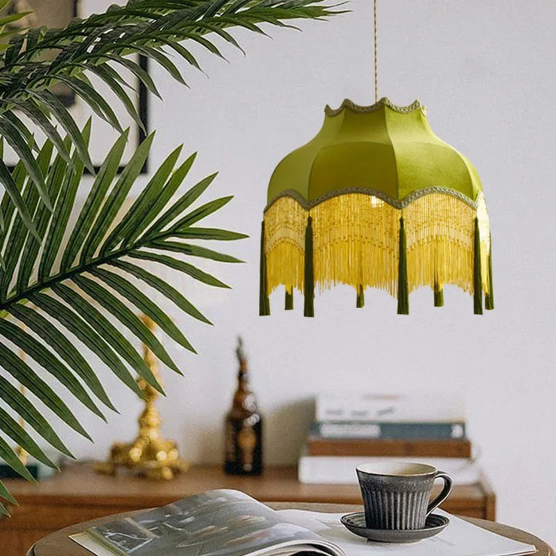 Vintage green fabric pendant light with tassels, suspended in a stylish living space with natural decor elements.