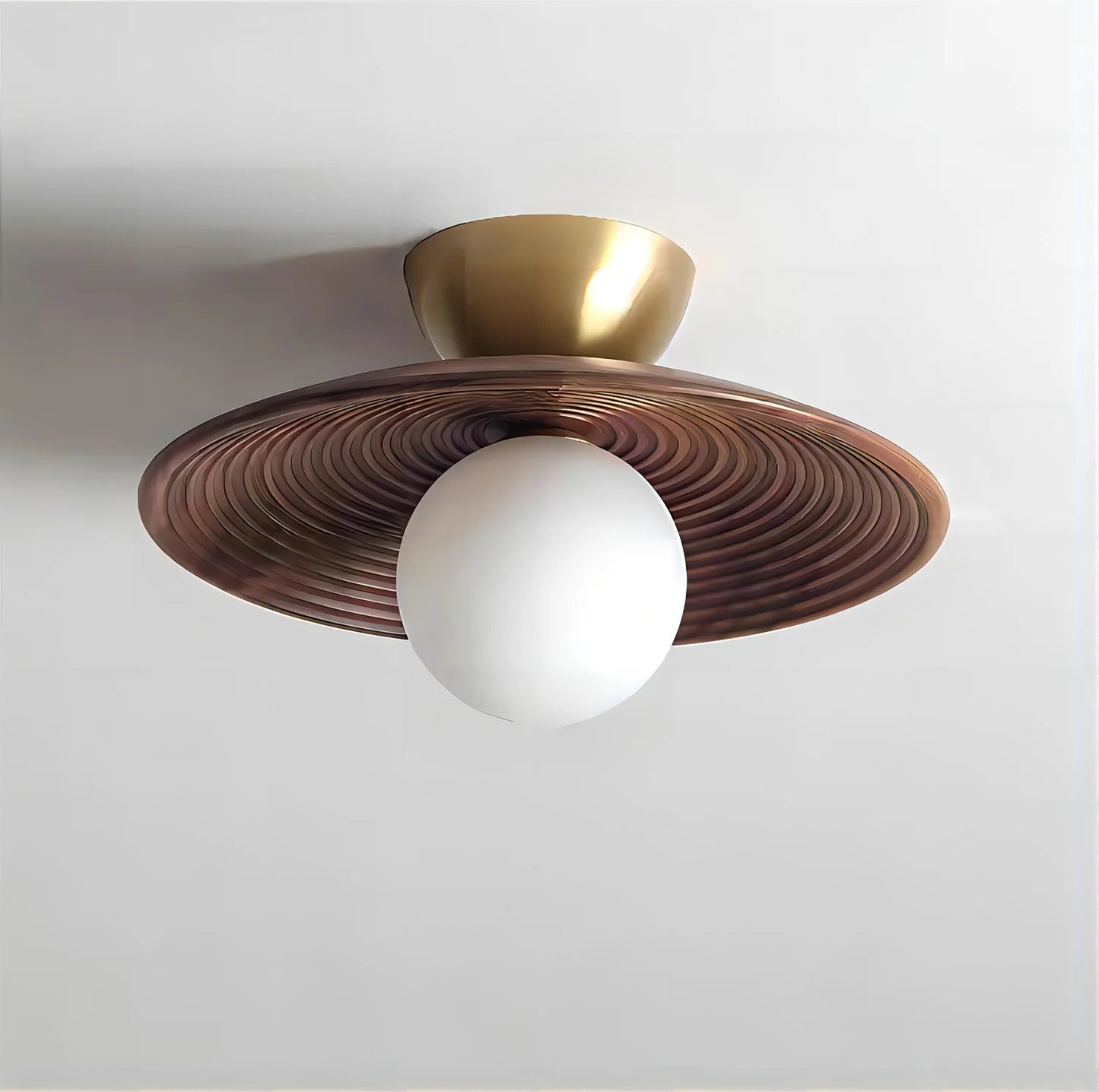 Wood flush mount ceiling light with brass accent and carved walnut shade, blending modern elegance with natural materials.