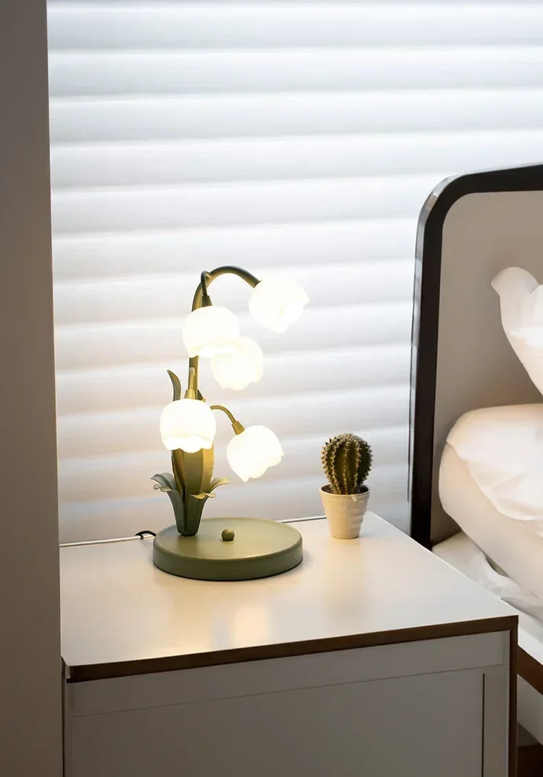 Nordic Atmosphere LED Table Lamp on a nightstand, offering soft floral lighting ideal for bedroom or bedside ambiance.