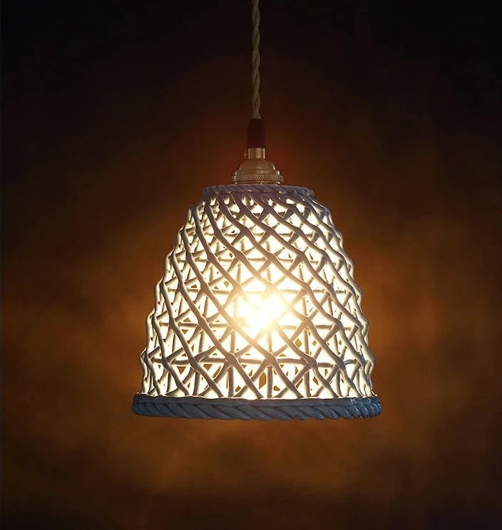 Illuminated blue LUXELY ceramic Japanese pendant light with warm glow, highlighting its intricate openwork ceramic pattern.