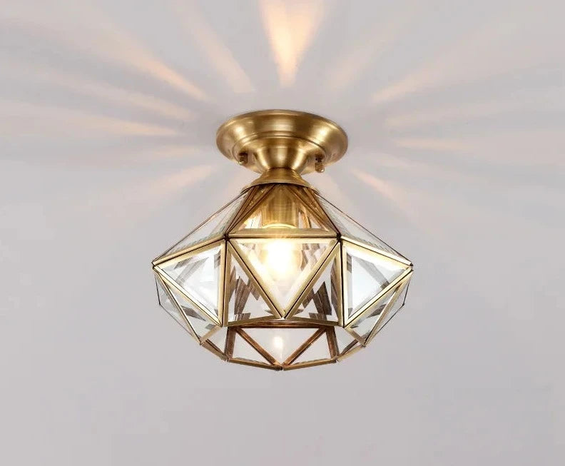 Modern copper ceiling light with faceted glass dome design, casting radiant light patterns on the ceiling.