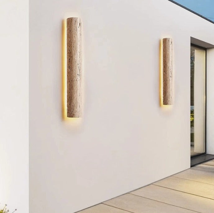 Pair of IP65 outdoor travertine wall lights mounted on white exterior wall, emitting warm light for elegant outdoor ambiance.