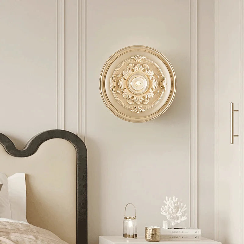 LUXELY round wall lamp in beige finish above a bed, blending vintage charm with functional lighting for bedrooms.