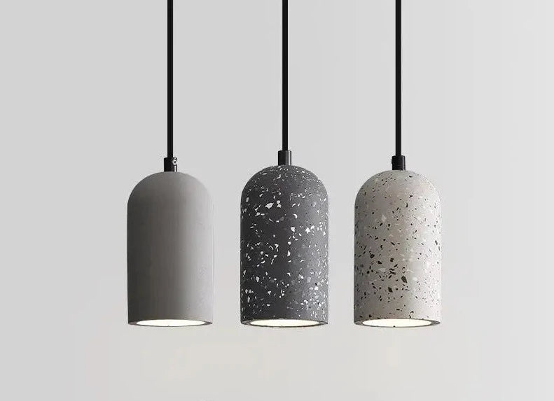 Industrial cement pendant lamp trio with terrazzo and matte finishes. Sleek minimalist lighting for kitchen or dining spaces.