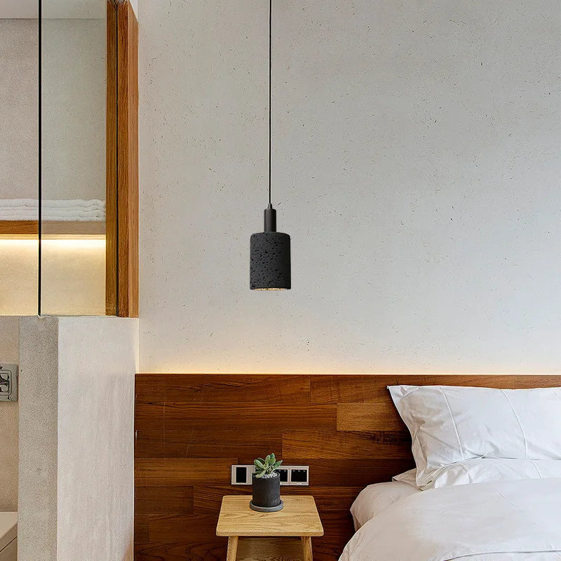 Compact black stone pendant light in a cozy bedroom, perfect for bedside or reading light with a modern industrial touch.