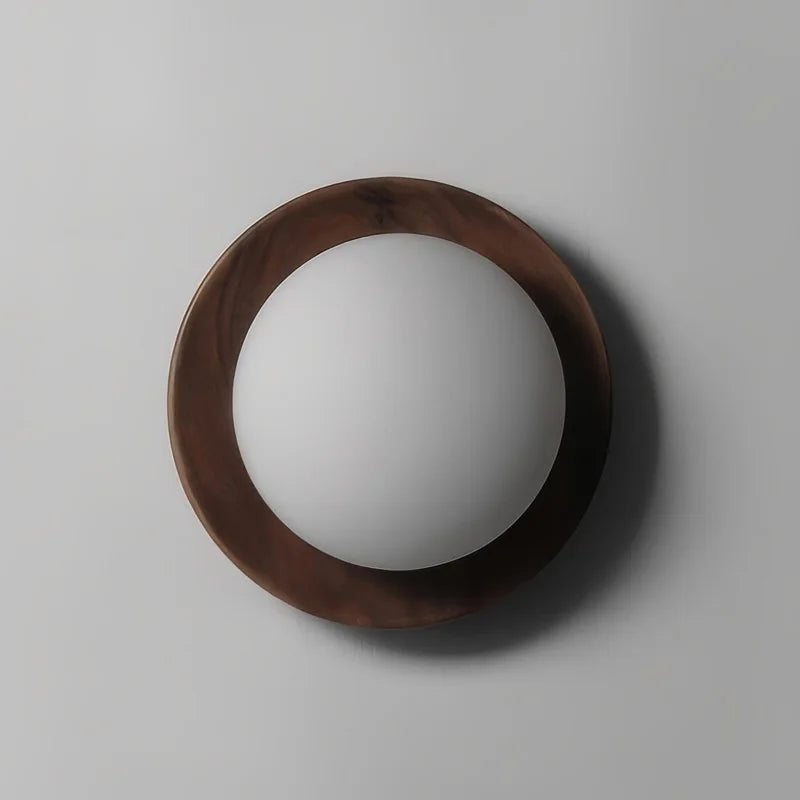 Front view of Nordic walnut wood wall lamp with frosted globe, ideal for living room or bedroom lighting.