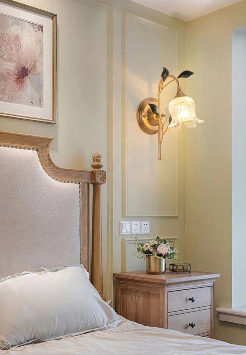 French Wall Sconce Light with LED floral shade installed beside a bed, enhancing bedroom ambiance with golden vintage elegance.