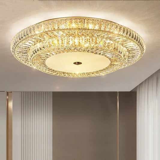 Golden crystal ceiling light - crystal round chandelier installed in a modern living room, radiating warm ambient lighting.