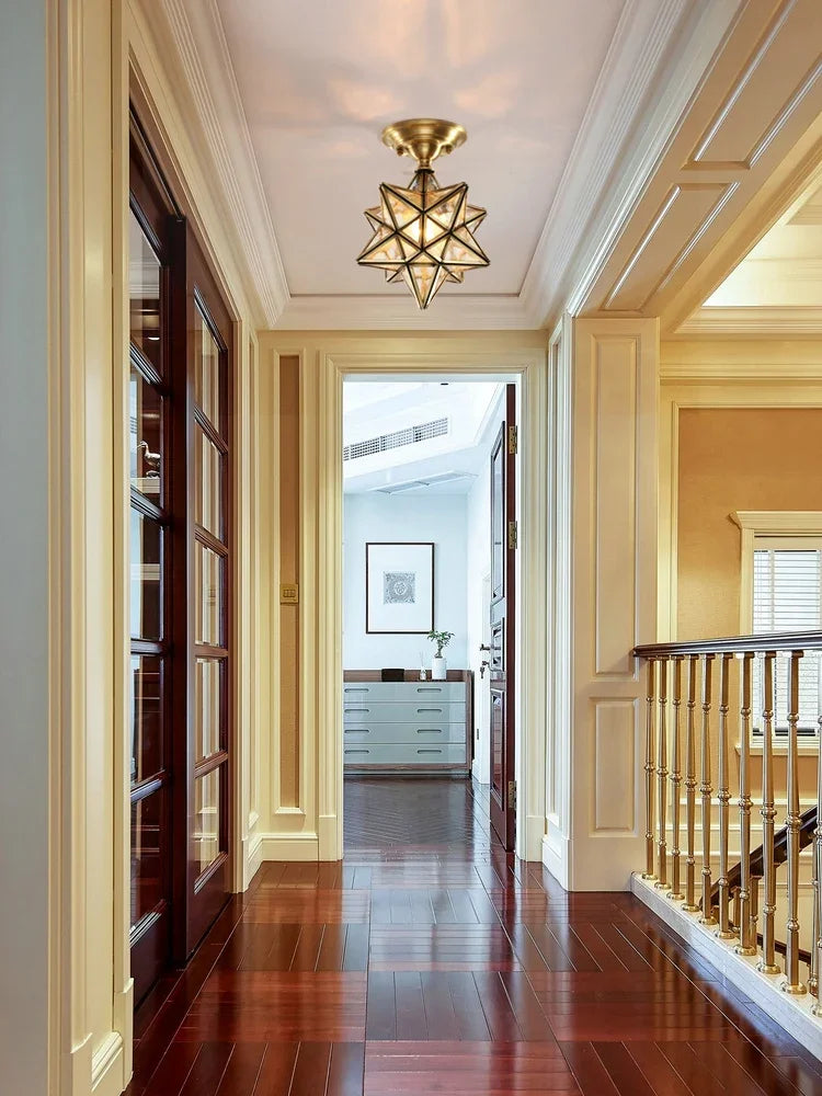 Copper flush mount ceiling light with glass star design, installed in a classic hallway for elegant lighting ambiance.