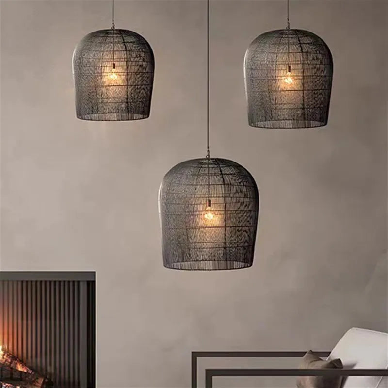 Set of three black LUXELY industrial rattan pendant lamps hanging in a living room, creating a warm, wabi-sabi ambiance.