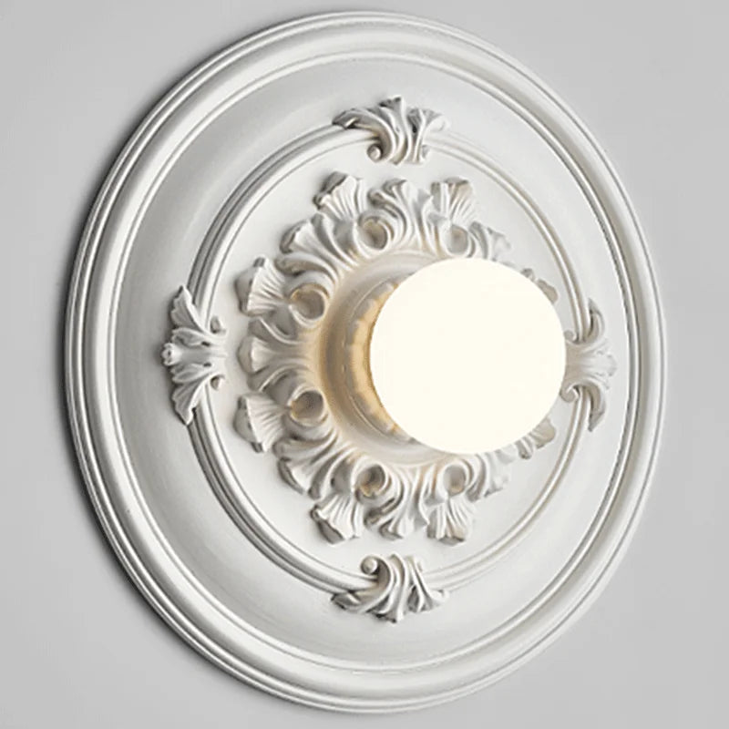 Close-up of LUXELY white round wall lamp with sculpted floral design, showcasing its retro-inspired craftsmanship.