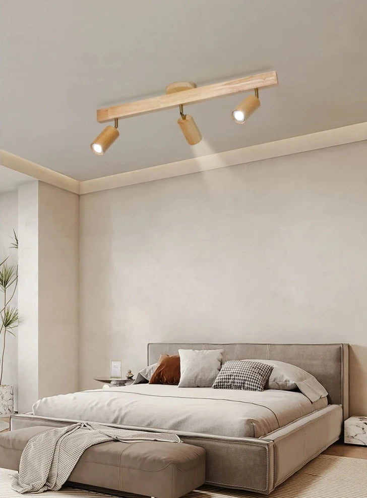 Light wood finish LUXELY LED spotlight in a neutral-toned bedroom, offering soft and adjustable Scandinavian ceiling lighting.