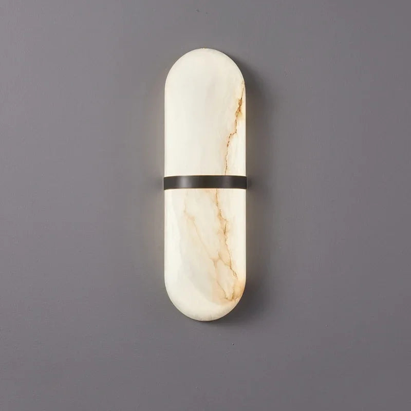 Warm-lit marble wall sconce with black brass accent, perfect for luxury home, hotel, or restaurant wall lighting.