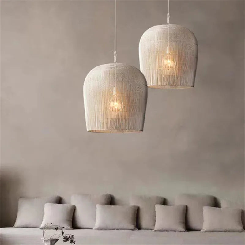 Pair of white LUXELY rattan pendant lights over a neutral-toned sofa, enhancing a minimalist living room with soft lighting.