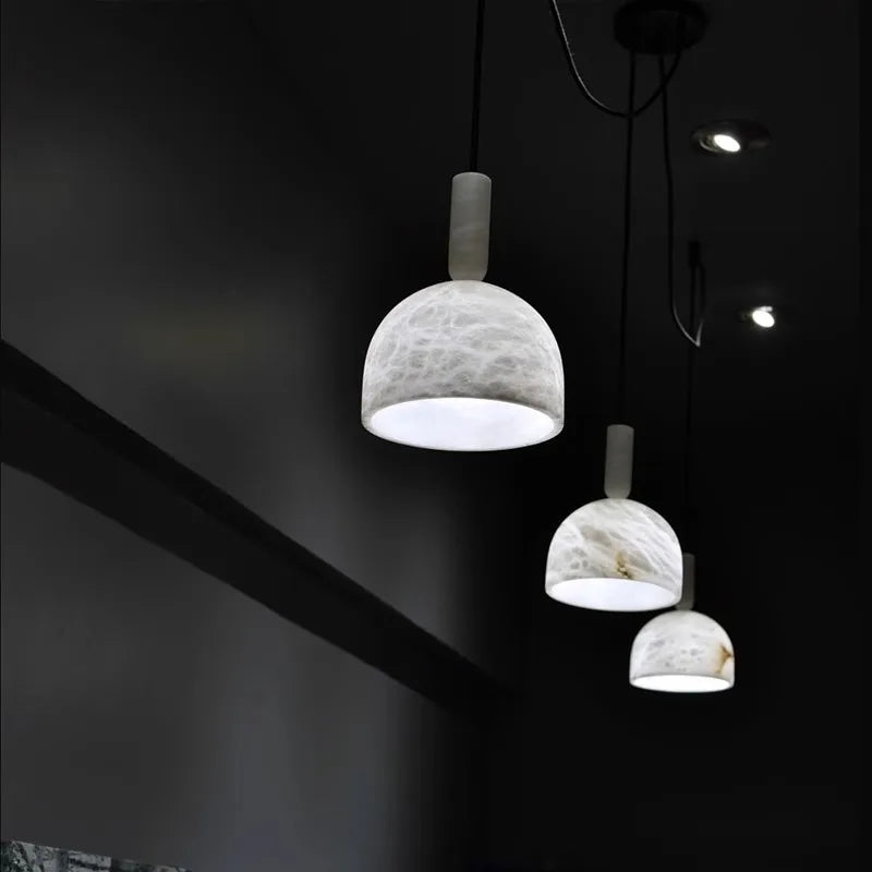Row of dome-shaped marble LED pendant lights in a dark hallway. Marble LED pendant light – modern ceiling lamp dimmable for ambient lighting.