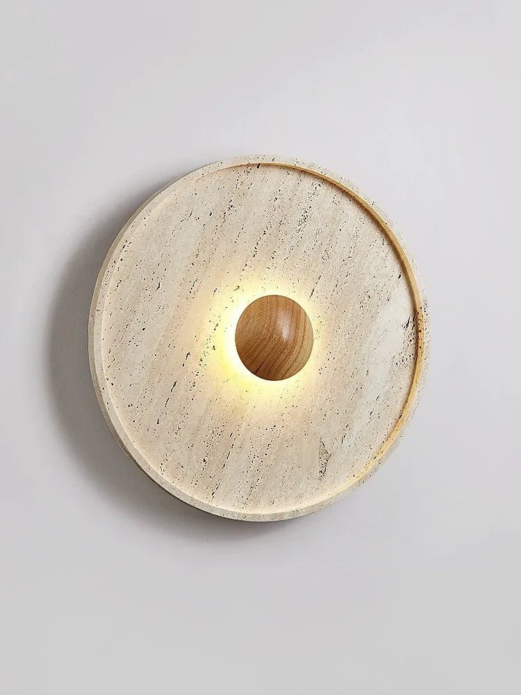 Round travertine Japanese wall lamp with glowing wooden LED center, blending wabi-sabi style and modern lighting design.