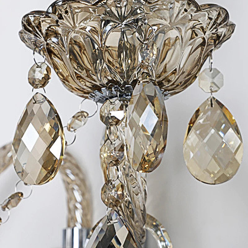 Close-up of vintage lotus-shaped crystal sconce with amber teardrop crystals, ideal for luxurious bedroom lighting.