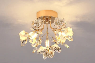 White kids rose crystal chandelier with gold accents and crystal leaves, offering a soft and elegant lighting solution for children's rooms.