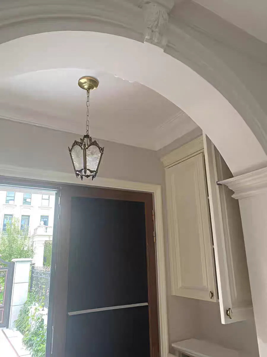Small copper French retro chandelier installed in a modern entryway. Compact and stylish lighting solution for transitional spaces.