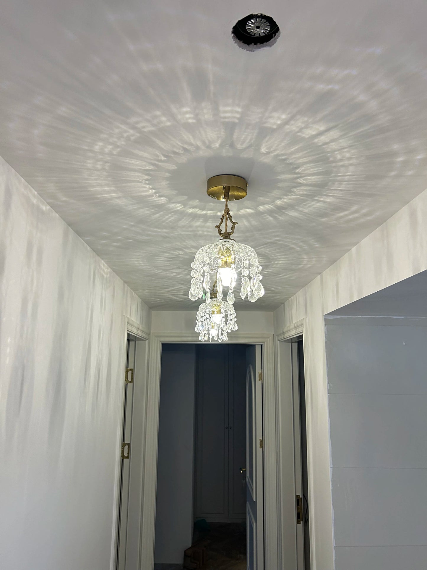French Vintage Crystal Chandelier - Copper Hanging Lamp in hallway with dual fixtures, creating elegant light patterns.
