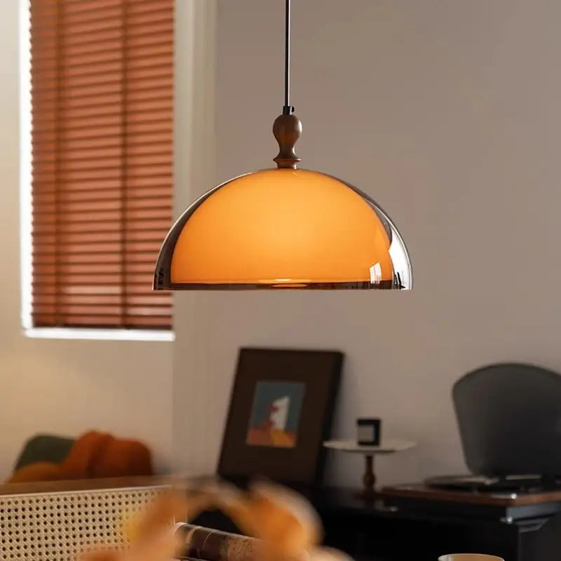 Sleek LED Pendant Light hanging over a cozy dining space, showcasing its modern amber glass dome and warm ambiance.