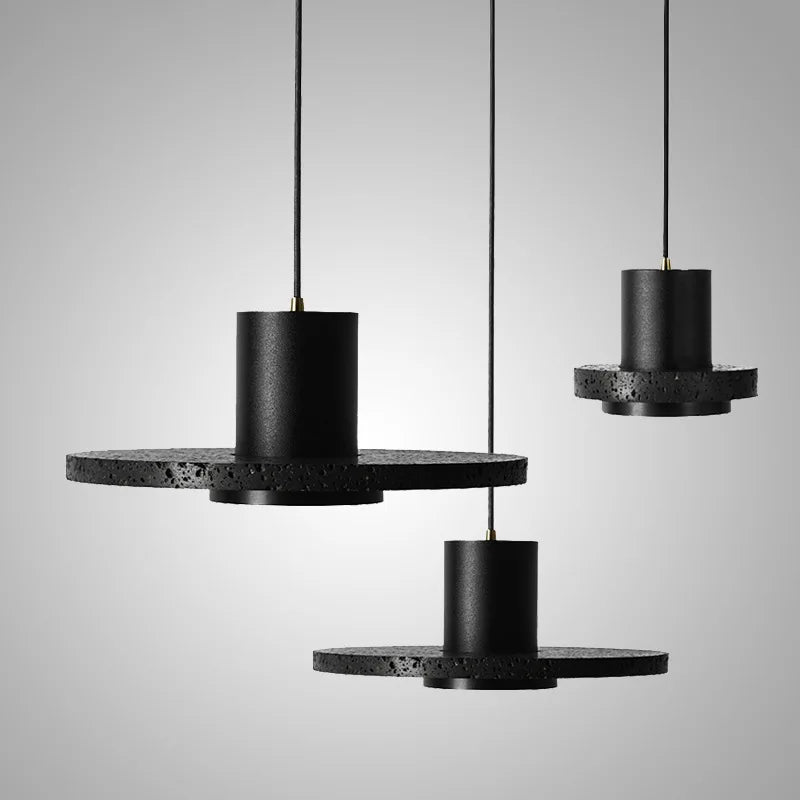 Set of three black stone pendant lights in industrial style, perfect for kitchen islands or restaurant lighting with a minimalist aesthetic.