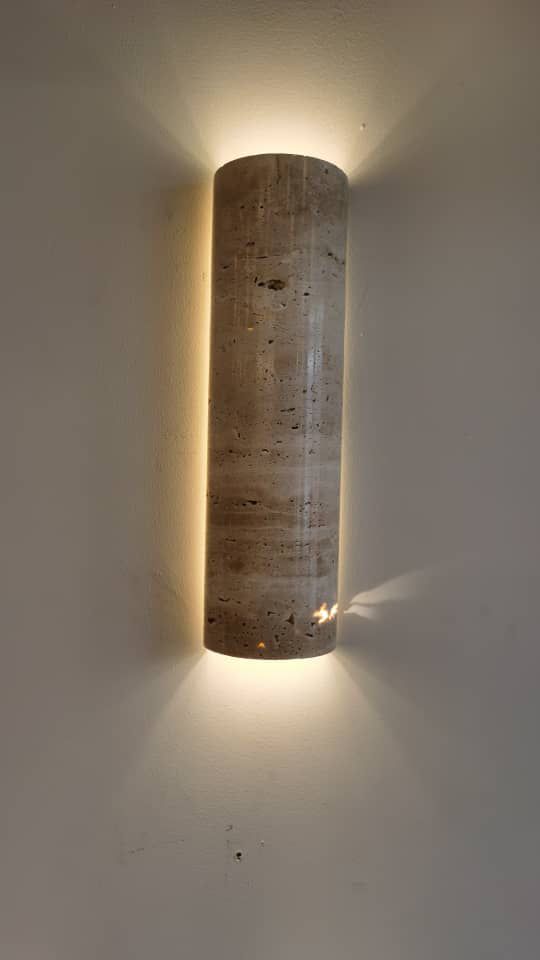 Wabi-sabi style IP65 Travertine wall lamp glowing warmly on a wall, ideal for bedroom or restaurant ambiance lighting.