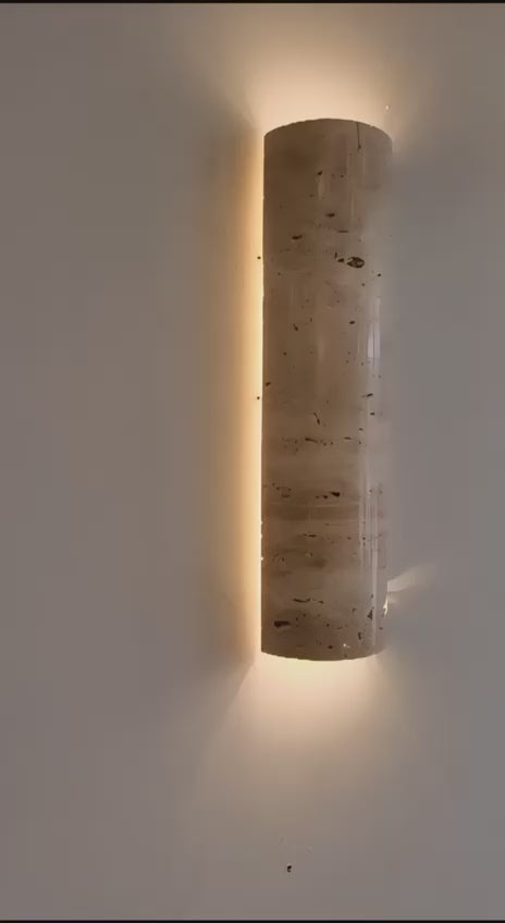 IP65 Travertine wall lamp mounted on wall with warm LED light, perfect for outdoor or indoor minimalist lighting solutions.