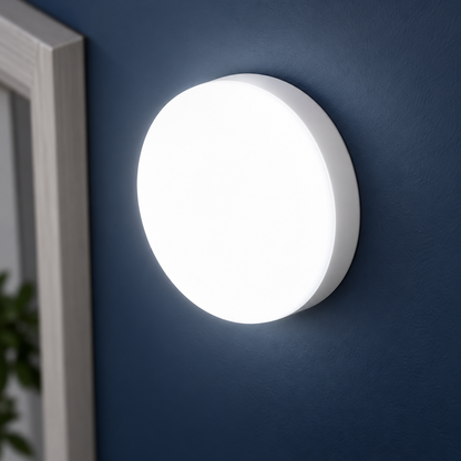 White slim round LED wall and ceiling light, close-up of its shallow white edge