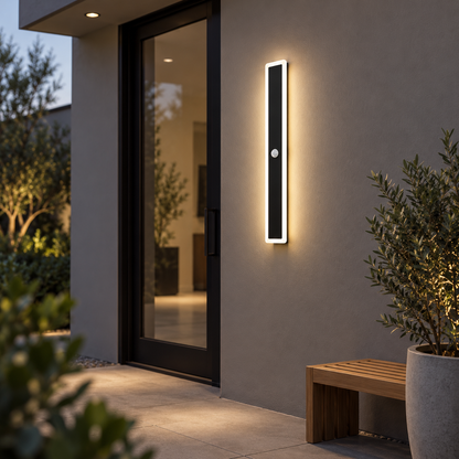 Black linear outdoor wall light with motion sensor, far front view in courtyard