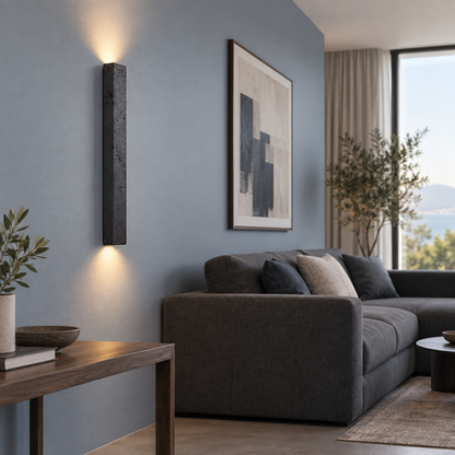 Slim black stone up and down wall light, far side view in a complete living room