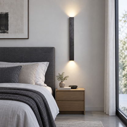 Slim black stone up and down wall light, far front view in a bedroom