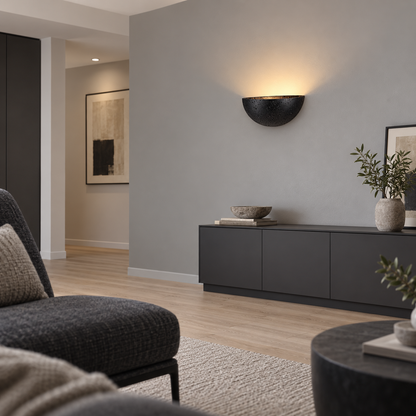 Side view of a black stone half-moon wall light installed in a sitting room