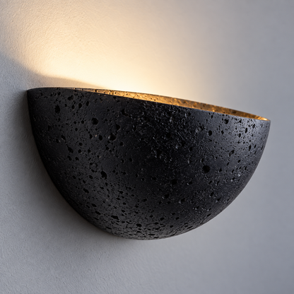 Close-up of the curved black stone underside of the half-moon wall light