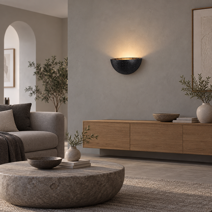 Black stone half-moon wall light installed above a living-room console