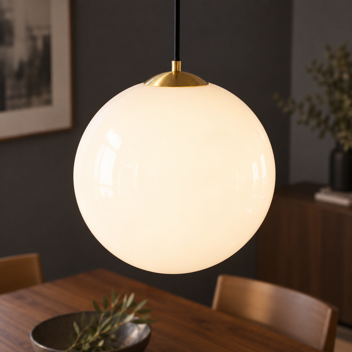 Close-up of white opal glass globe and gold fitting on adjustable pendant light