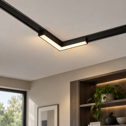 Black L-shaped 10W magnetic corner floodlight installed in recessed ceiling rails above an oak shelving area, lit with warm light