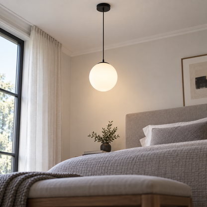 Small white glass globe pendant with black fittings, low underside view installed in bedroom