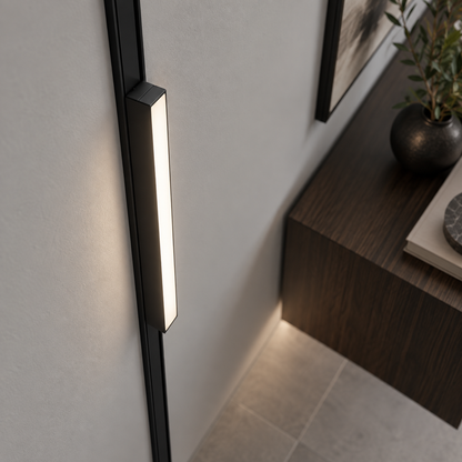 Elevated view of a black linear LED module installed on a vertical wall track
