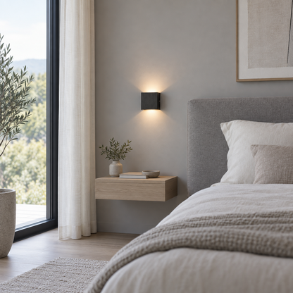 Black brushed wall light on a smooth grey bedroom wall