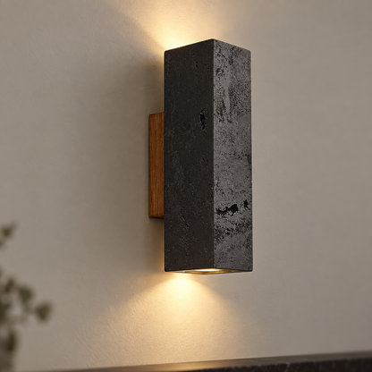 Black square travertine wall light in the 23 cm size, centered on a smooth taupe wall