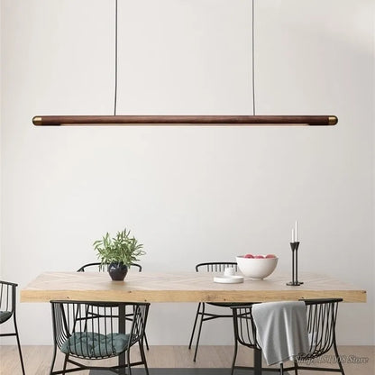 Wooden Black Walnut Pendant Light suspended over a minimalist dining setup, blending rustic charm with contemporary elegance.